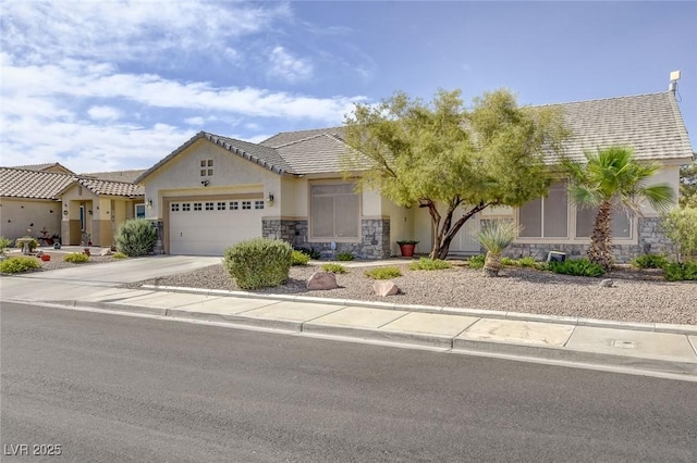 1408 Reebok Ter, Henderson, NV 89014 - view of front of home with stone siding, stucco siding, a garage, and concrete driveway