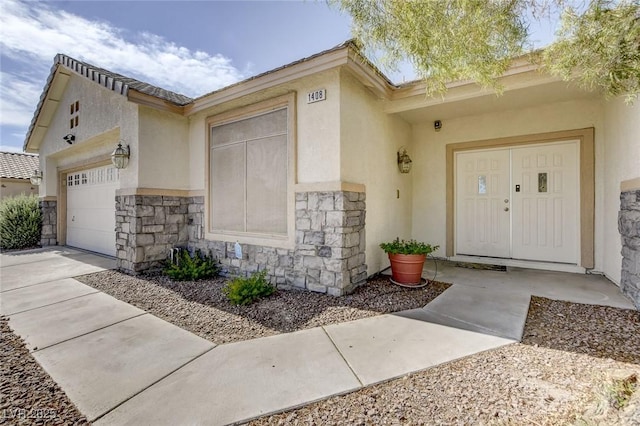 1408 Reebok Ter, Henderson, NV 89014 - doorway to property featuring stucco siding, stone siding, an attached garage, and driveway