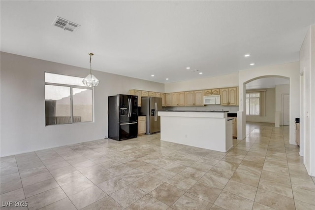 1408 Reebok Ter, Henderson, NV 89014 - kitchen with black fridge with ice dispenser, stainless steel fridge, white microwave, arched walkways, and light brown cabinets
