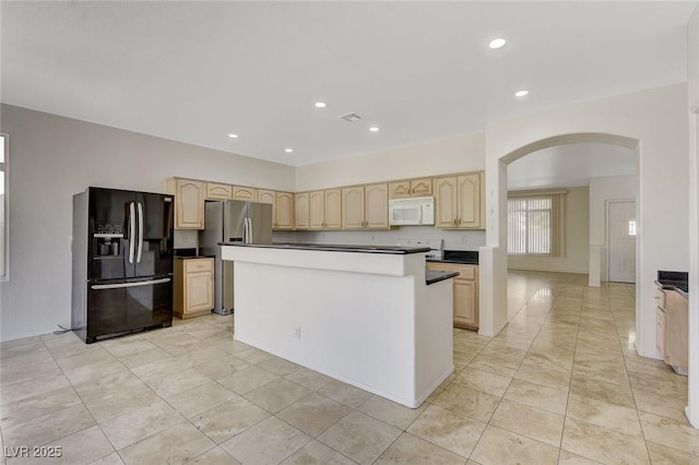 1408 Reebok Ter, Henderson, NV 89014 - kitchen with black fridge, white microwave, light brown cabinets, arched walkways, and freestanding refrigerator