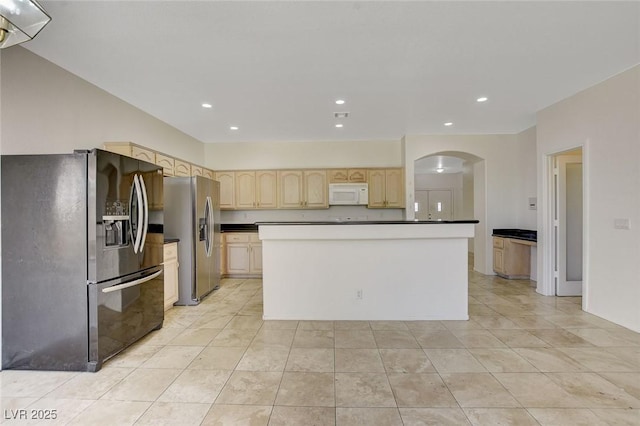 1408 Reebok Ter, Henderson, NV 89014 - kitchen with black refrigerator with ice dispenser, white microwave, stainless steel fridge, light brown cabinets, and arched walkways