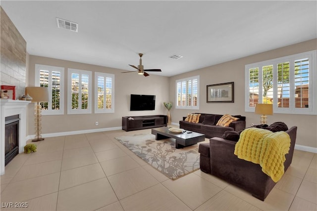 5542 Oak Bend Dr, Las Vegas, NV 89135 - living area featuring a ceiling fan, a glass covered fireplace, and tile patterned flooring
