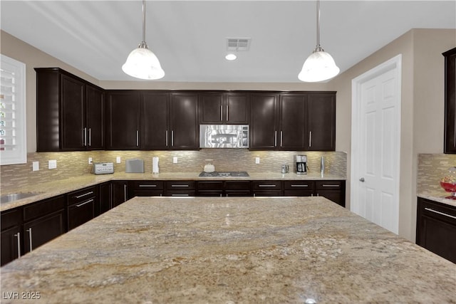 5542 Oak Bend Dr, Las Vegas, NV 89135 - kitchen with appliances with stainless steel finishes, light stone countertops, tasteful backsplash, and dark brown cabinets
