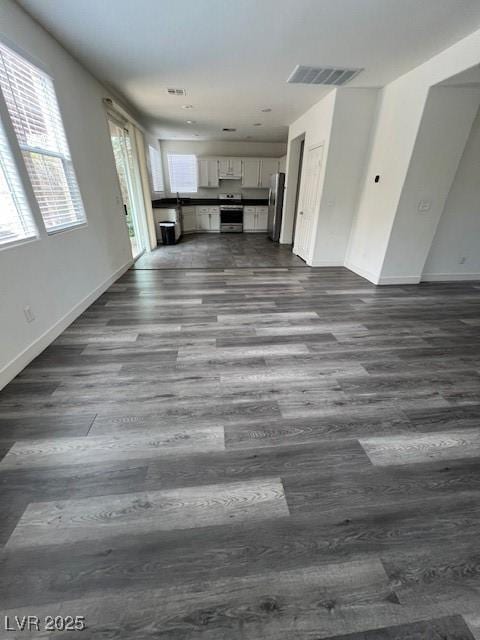 11173 Hickory Glen St, Las Vegas, NV 89179 - unfurnished living room featuring dark wood-style flooring and baseboards