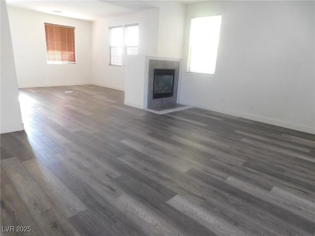 11173 Hickory Glen St, Las Vegas, NV 89179 - unfurnished living room with a tile fireplace, baseboards, and dark wood-style flooring