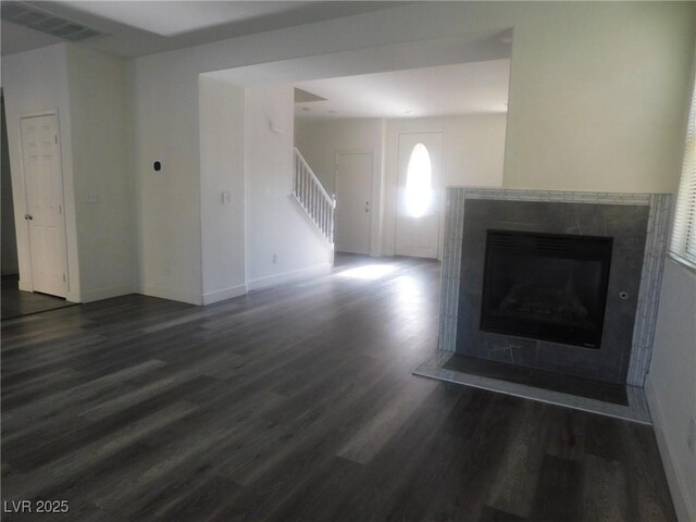 11173 Hickory Glen St, Las Vegas, NV 89179 - unfurnished living room featuring wood finished floors, stairway, a fireplace with flush hearth, and baseboards