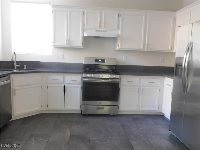11173 Hickory Glen St, Las Vegas, NV 89179 - kitchen with stainless steel appliances, under cabinet range hood, white cabinetry, a sink, and dark countertops