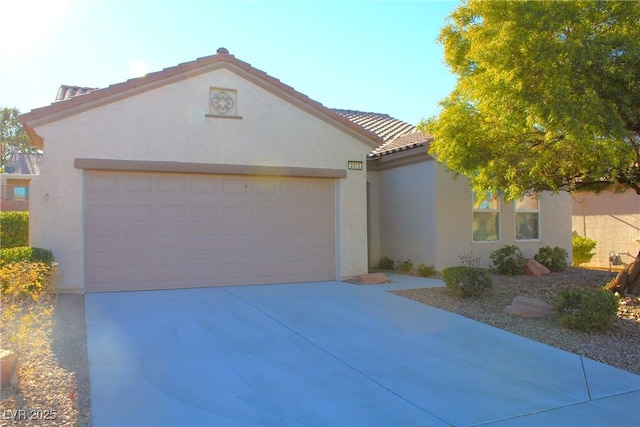2212 Sawtooth Mountain Dr, Henderson, NV 89044 - mediterranean / spanish-style house featuring stucco siding, concrete driveway, an attached garage, and a tiled roof