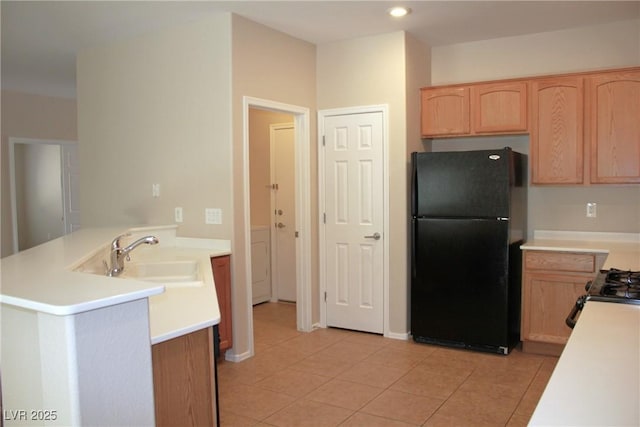 2212 Sawtooth Mountain Dr, Henderson, NV 89044 - kitchen featuring freestanding refrigerator, a peninsula, a sink, light brown cabinetry, and light countertops