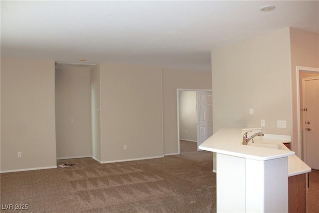 2212 Sawtooth Mountain Dr, Henderson, NV 89044 - kitchen featuring a sink, light countertops, a peninsula, carpet, and baseboards