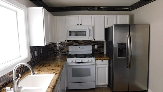3606 Gold Sluice Ave, North Las Vegas, NV 89032 - kitchen featuring white appliances, a sink, backsplash, and white cabinets