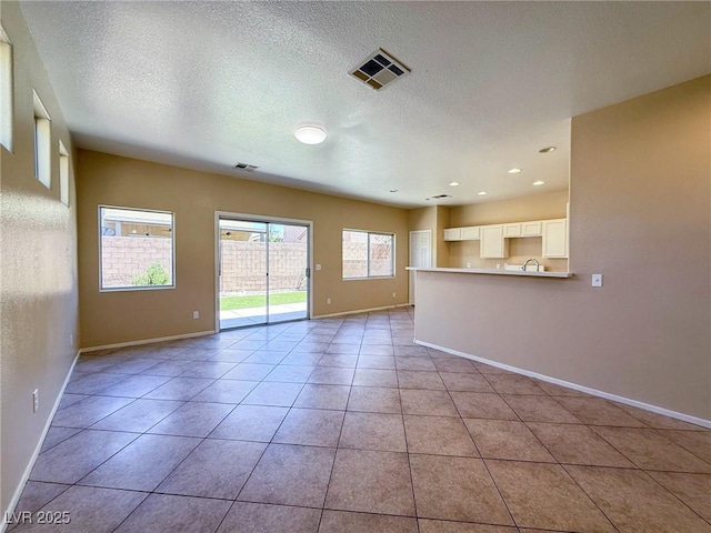 3736 Gallowtree Ave, North Las Vegas, NV 89081 - unfurnished living room featuring a textured ceiling, light tile patterned floors, and recessed lighting