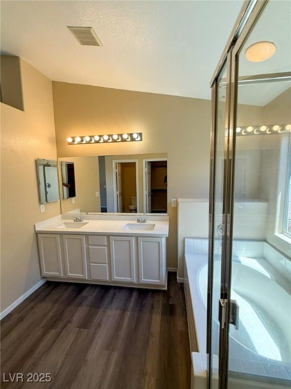 3736 Gallowtree Ave, North Las Vegas, NV 89081 - bathroom with a bath, double vanity, wood finished floors, lofted ceiling, and a shower stall