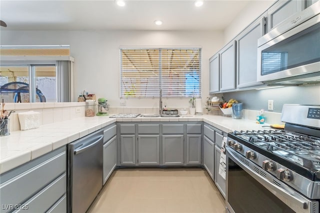 2789 Trotwood Ln, Las Vegas, NV 89108 - kitchen featuring stainless steel appliances, a sink, gray cabinetry, recessed lighting, and plenty of natural light