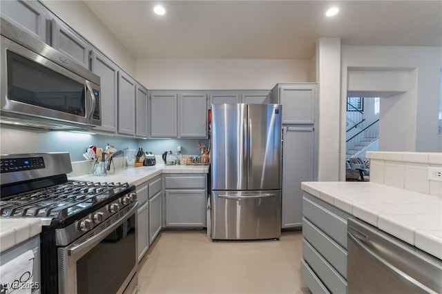 2789 Trotwood Ln, Las Vegas, NV 89108 - kitchen with appliances with stainless steel finishes, gray cabinets, tile countertops, and recessed lighting