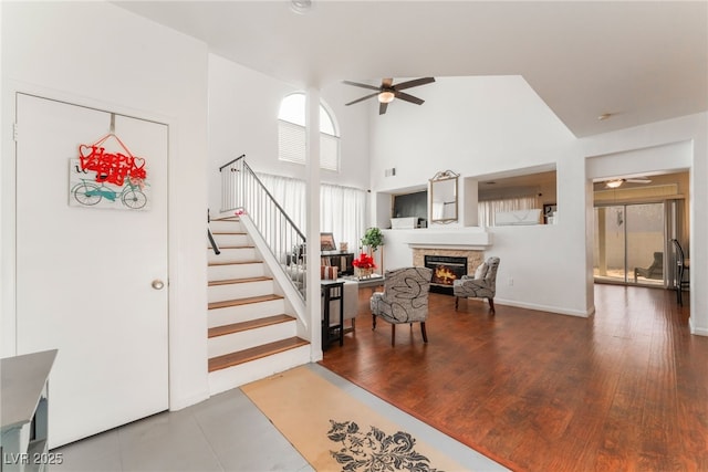 2789 Trotwood Ln, Las Vegas, NV 89108 - living area with ceiling fan, stairway, a stone fireplace, and a towering ceiling