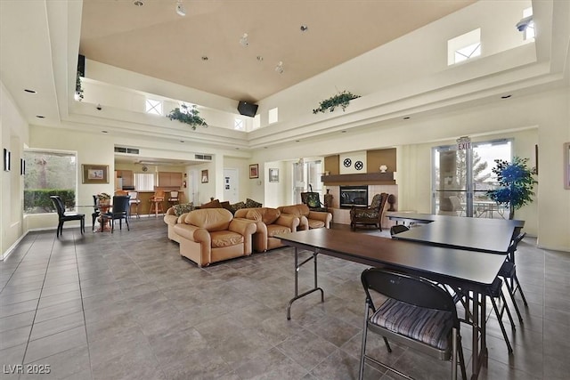 8070 W Russell Rd Unit 1036, Las Vegas, NV 89113 - tiled living area featuring a tray ceiling, a high ceiling, and a glass covered fireplace