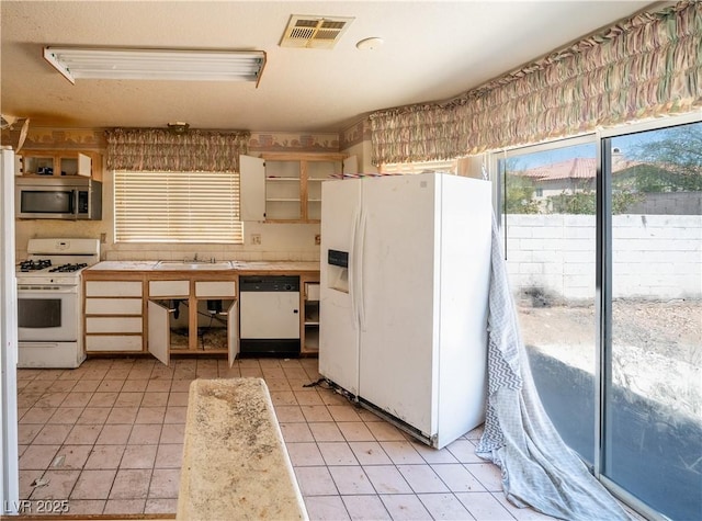 1436 Padre Bay Dr, Las Vegas, NV 89108 - kitchen featuring white appliances, open shelves, light tile patterned flooring, light countertops, and a sink