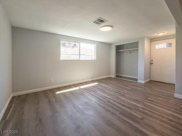 2713 Valley St, Las Vegas, NV 89101 - unfurnished bedroom featuring wood finished floors, baseboards, a textured ceiling, and a closet
