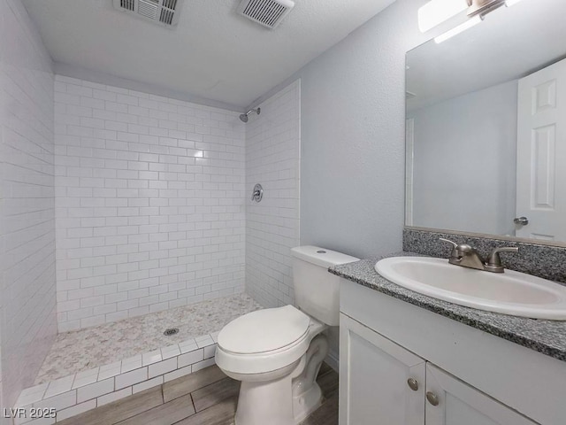 2713 Valley St, Las Vegas, NV 89101 - full bathroom featuring vanity, tiled shower, toilet, and wood finished floors