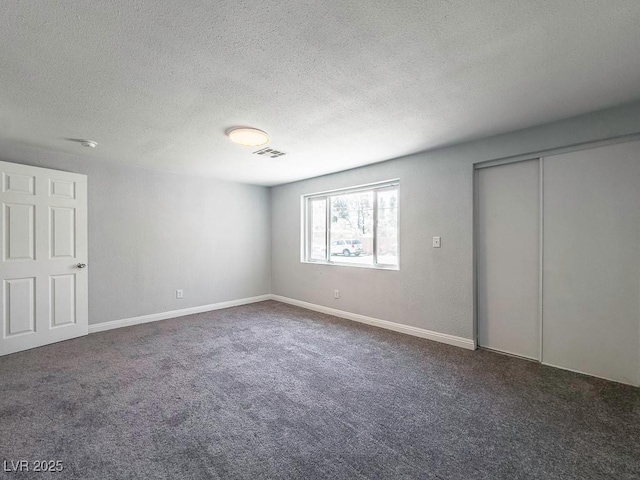 2713 Valley St, Las Vegas, NV 89101 - unfurnished bedroom featuring carpet floors, a textured ceiling, a closet, and baseboards