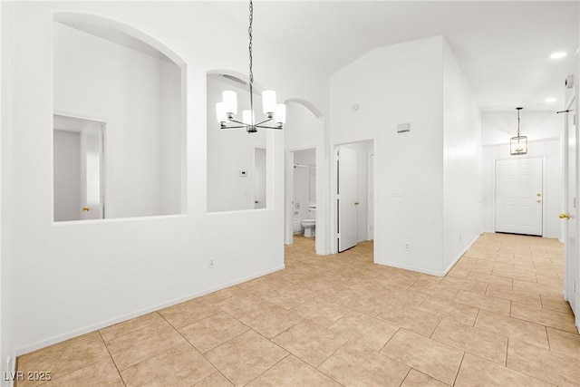 5112 Foggia Ave, Las Vegas, NV 89130 - empty room featuring a chandelier, arched walkways, tile patterned floors, baseboards, and high vaulted ceiling