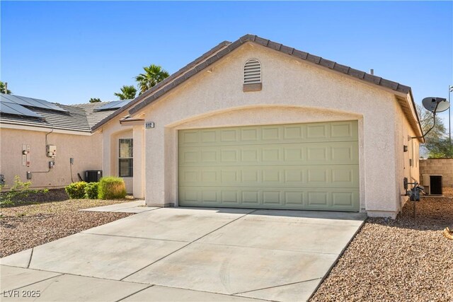 5112 Foggia Ave, Las Vegas, NV 89130 - view of front of property featuring stucco siding, an attached garage, concrete driveway, solar panels, and central air condition unit