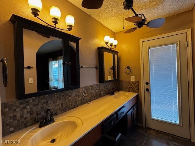 6421 Doby Peak Dr, Las Vegas, NV 89108 - full bath with decorative backsplash, lofted ceiling, a textured ceiling, tile patterned floors, and double vanity