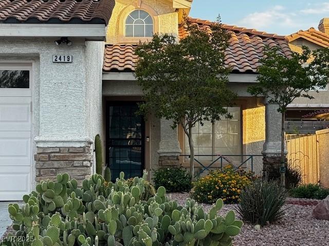 2419 Pebble Springs Ct, Henderson, NV 89074 - entrance to property with a tile roof, stone siding, and stucco siding
