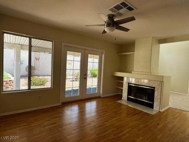 2419 Pebble Springs Ct, Henderson, NV 89074 - unfurnished living room with a high end fireplace, wood finished floors, ceiling fan, and healthy amount of natural light