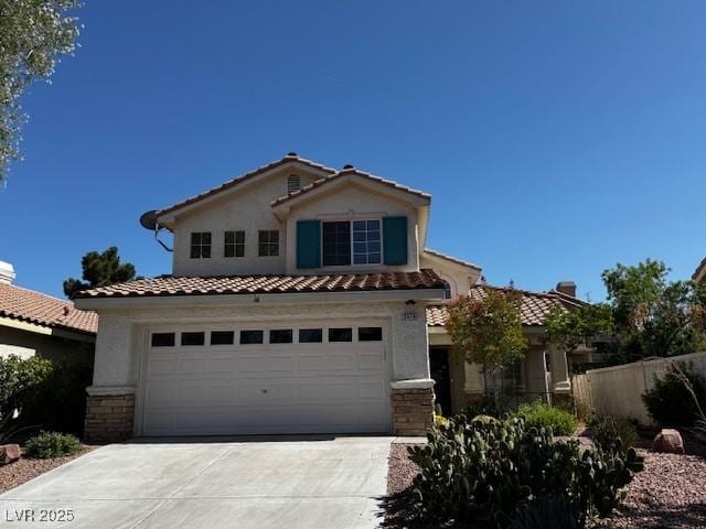 2419 Pebble Springs Ct, Henderson, NV 89074 - view of front facade featuring a tile roof, concrete driveway, stucco siding, a garage, and stone siding