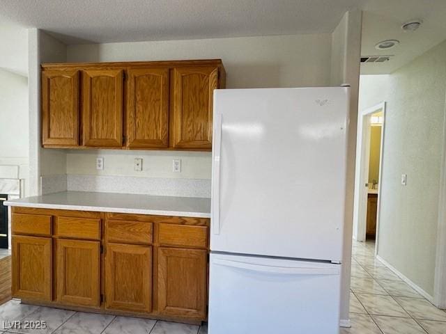 2419 Pebble Springs Ct, Henderson, NV 89074 - kitchen with freestanding refrigerator, brown cabinets, and light countertops