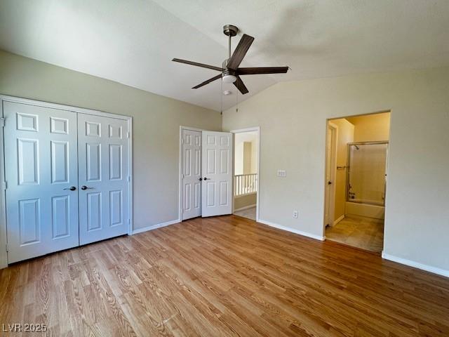 2419 Pebble Springs Ct, Henderson, NV 89074 - unfurnished bedroom with vaulted ceiling, two closets, wood finished floors, ensuite bathroom, and ceiling fan
