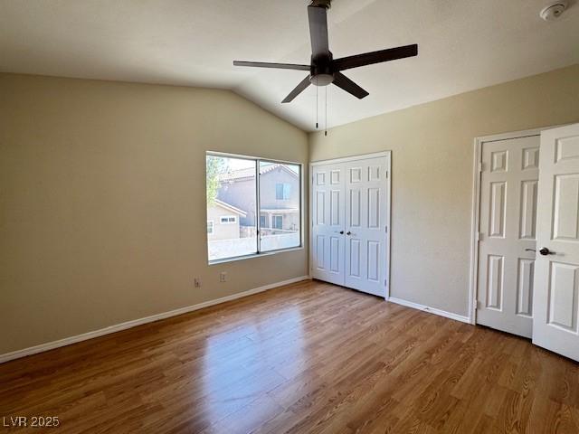 2419 Pebble Springs Ct, Henderson, NV 89074 - unfurnished bedroom with wood finished floors, lofted ceiling, a ceiling fan, and multiple closets