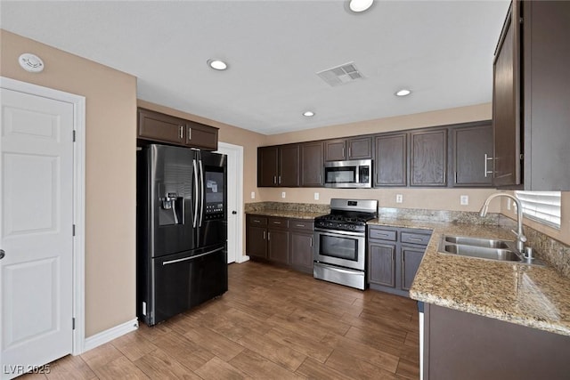 5816 Glory Canyon Way, Las Vegas, NV 89142 - kitchen featuring appliances with stainless steel finishes, a sink, dark brown cabinetry, light wood-style flooring, and recessed lighting