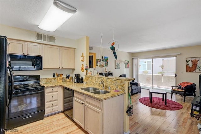 5196 Mandalay Springs Dr Unit 101, Las Vegas, NV 89120 - kitchen with black appliances, a peninsula, light wood-style flooring, and light brown cabinetry