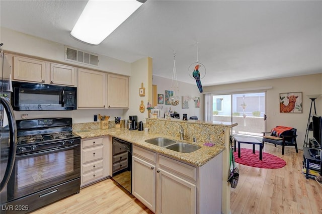 5196 Mandalay Springs Dr Unit 101, Las Vegas, NV 89120 - kitchen featuring black appliances, a peninsula, light wood-style flooring, light stone counters, and light brown cabinetry