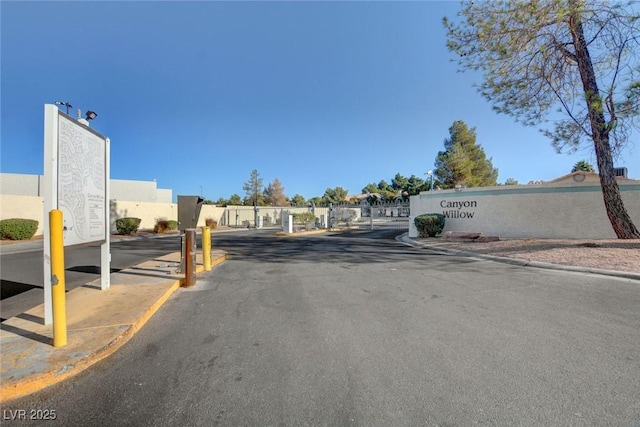 5196 Mandalay Springs Dr Unit 101, Las Vegas, NV 89120 - view of asphalt road with curbs, sidewalks, a gated entry, and a gate