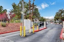 5196 Mandalay Springs Dr Unit 101, Las Vegas, NV 89120 - view of asphalt street featuring a gated entry, a gate, and curbs