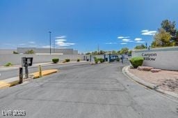 5196 Mandalay Springs Dr Unit 101, Las Vegas, NV 89120 - view of asphalt street with curbs, street lighting, and a gated entry