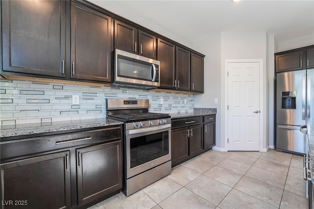 7732 Bandon Cliffs St, North Las Vegas, NV 89084 - kitchen featuring stainless steel appliances, stone counters, backsplash, dark brown cabinetry, and light tile patterned floors