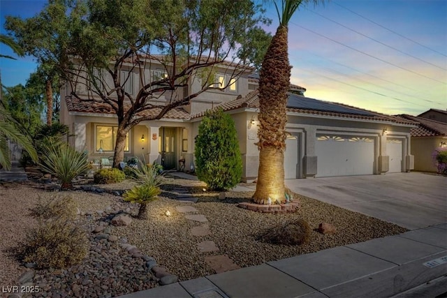 1306 Big Tree Ave, North Las Vegas, NV 89031 - mediterranean / spanish-style house with solar panels, driveway, stucco siding, a garage, and a tiled roof