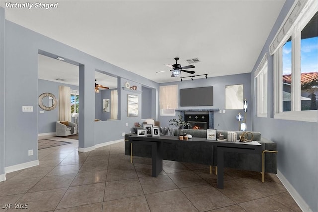 1306 Big Tree Ave, North Las Vegas, NV 89031 - living area featuring ceiling fan, a fireplace, tile patterned flooring, and baseboards