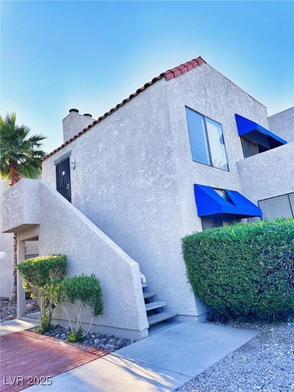 4331 Sanderling Cir Unit 46, Las Vegas, NV 89103 - view of side of property with a chimney, stucco siding, and a tiled roof