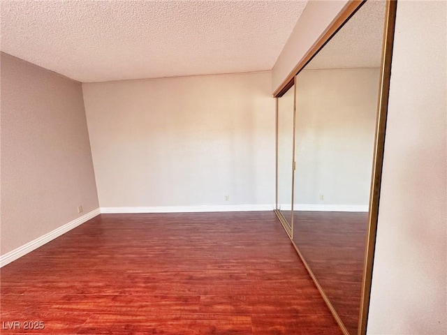 4331 Sanderling Cir Unit 46, Las Vegas, NV 89103 - unfurnished bedroom featuring wood finished floors, a closet, a textured ceiling, and baseboards