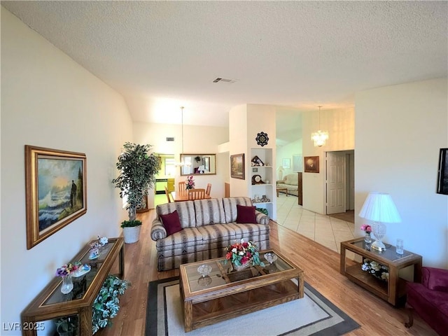 1536 Brocado Ln, Las Vegas, NV 89117 - living room with a chandelier, a textured ceiling, and light wood-style floors