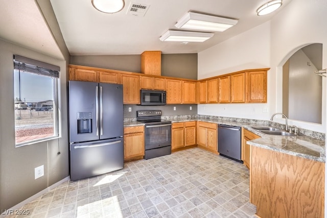 861 S Ford Loop, Pahrump, NV 89048 - kitchen with appliances with stainless steel finishes, vaulted ceiling, a sink, light stone countertops, and arched walkways