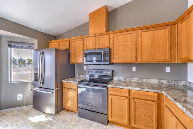861 S Ford Loop, Pahrump, NV 89048 - kitchen featuring appliances with stainless steel finishes, lofted ceiling, brown cabinetry, and baseboards
