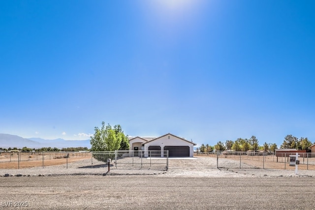 861 S Ford Loop, Pahrump, NV 89048 - view of front of home featuring an attached garage, driveway, an outdoor structure, a view of countryside, and a mountain view