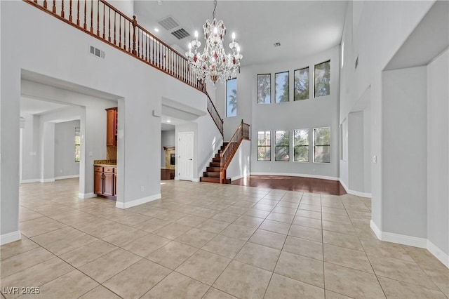 9008 Sawhill Pond St, Las Vegas, NV 89131 - unfurnished living room featuring light tile patterned flooring, a towering ceiling, stairs, a chandelier, and baseboards